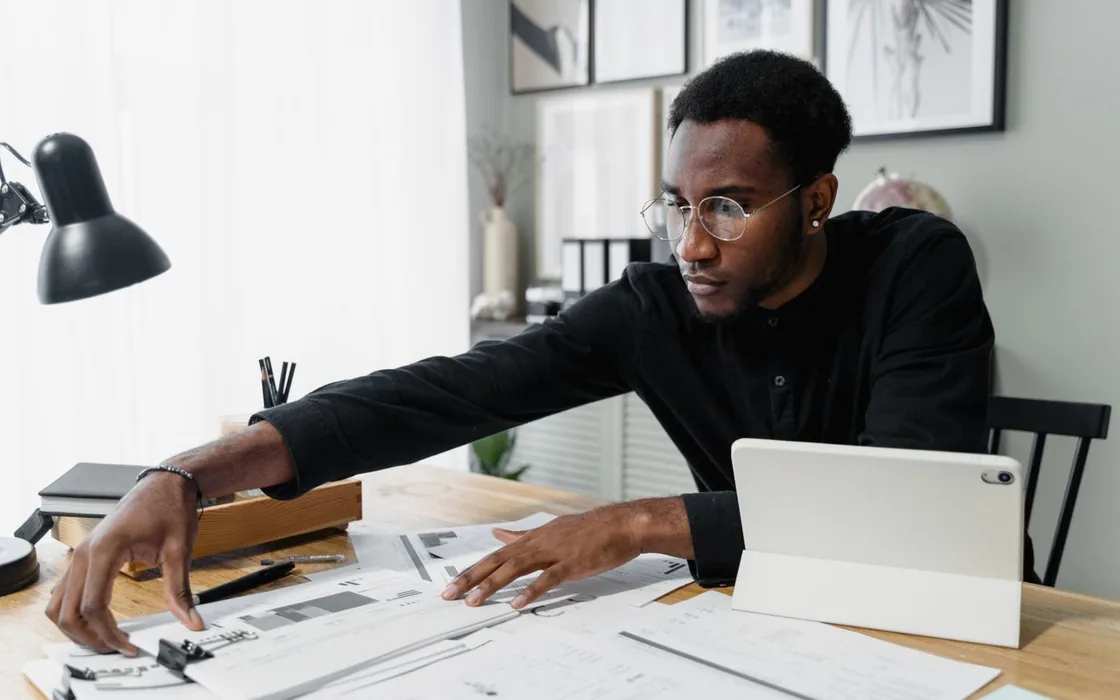 Business owner sorting through scattered paperwork on a desk