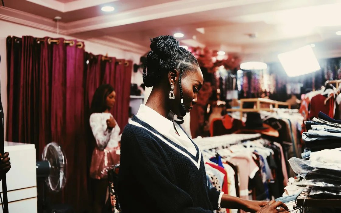 Shop assistant checking a phone in a busy boutique in Abuja